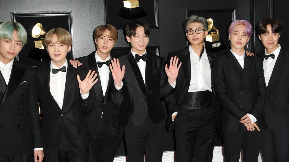 A group shot of a number of young Korean men in tuxedos